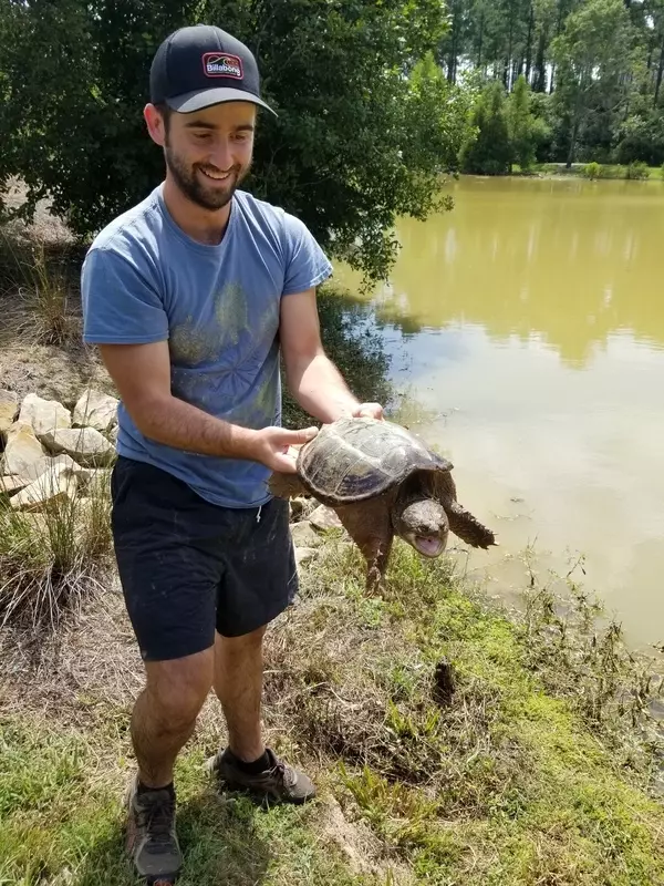 Student holding a common snapping turtle