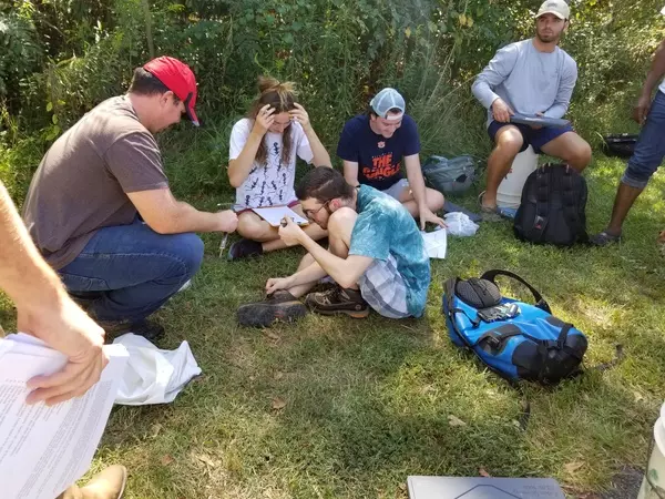 Students holding another tiny juvenile turtle